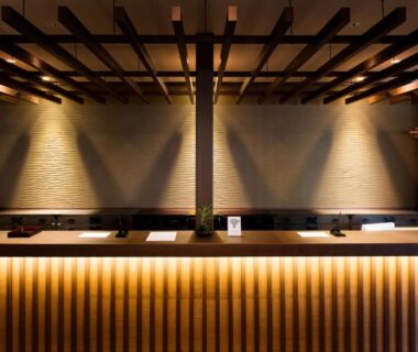 Wooden reception counter at Umiusagi in Shizuoka Chūbu with warm lighting and ceiling beams