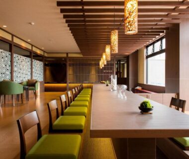 Long wooden table with green chairs in Umiusagi lounge, Shizuoka