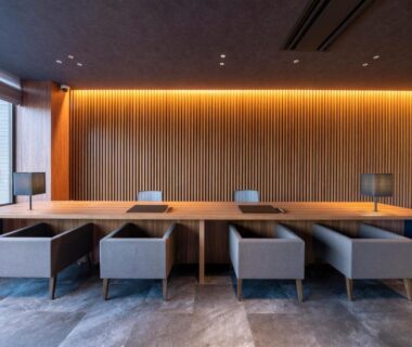 Long communal table with upholstered chairs and wood-slat wall at Urari Takeo Garden Terrace Spa Resorts, Saga