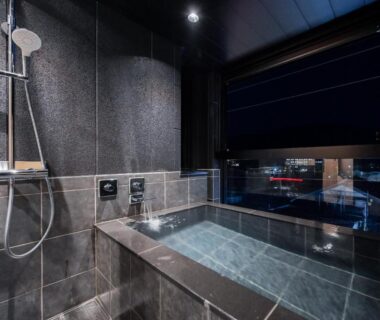 Indoor tiled soaking tub with night city view at Ureshino Onsen Yadoya Uchiroji Saga