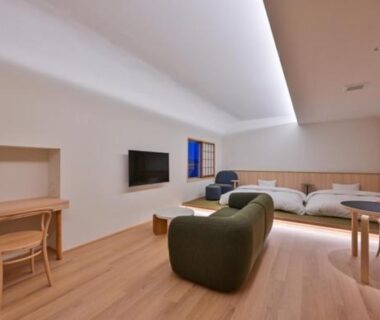 Spacious modern guest room with low seating, low platform beds and wooden floor at Ureshino Onsen Yusyuku Sarayama, Saga