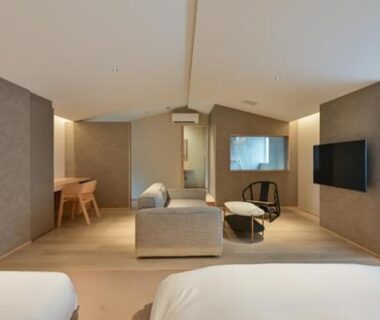 Two beds with sofa and shoji window in a modern guest room at Ureshino Onsen Yusyuku Sarayama, Saga, Kyushu