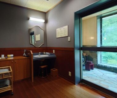 Interior wash area with basin and adjacent stone bath visible at Uruoikan, Nagano