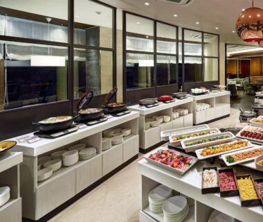 Buffet layout with hot chafing dishes and assorted plated dishes in ryokan dining area, Village Izukogen Shizuoka