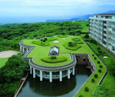 Rooftop garden and circular terrace above reflecting pond at Village Izukogen, coastal Shizuoka setting