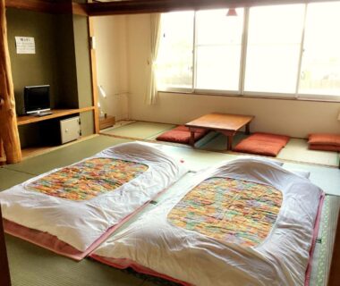 Two futon mattresses on tatami with low table and cushions at Village Sun Lake Kawaguchiko, Yamanashi