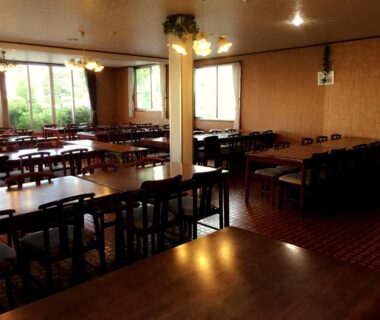 Communal wooden dining tables and chairs in Village Sun Lake Kawaguchiko dining hall, Yamanashi