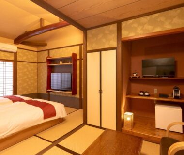 Japanese-style room with tatami mats, low table, western bed and shoji screens at Wa no Yado Sagiritei, Ōita