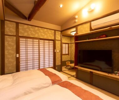 Tatami room with twin futons, shoji screens and TV cabinet at Wa no Yado Sagiritei in Oita