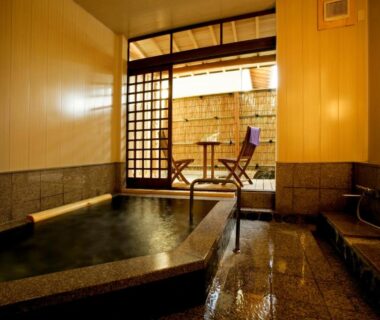 Stone indoor bath with shoji screens opening to a small terrace at Wafu-no-Yado MASUYA, Nagano