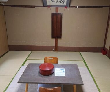 Traditional tatami room with low chairs and shoji screens at Wajimaya Ryokan in Kyoto