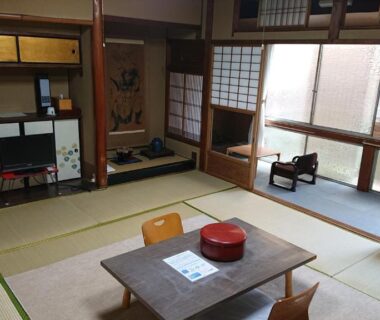Traditional tatami room with low table, zabuton chairs and shoji screens at Wajimaya Ryokan, Kyoto