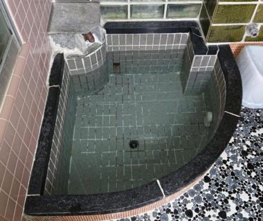 Small tiled soaking tub with wash stools and tiled floor in Wajimaya Ryokan bath Kyoto