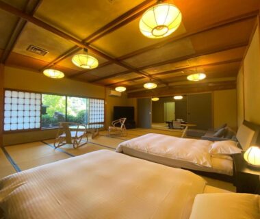 Spacious tatami room with two beds, shoji screens, low wooden lamps and garden view at Wakamatsu HakoneYugawara