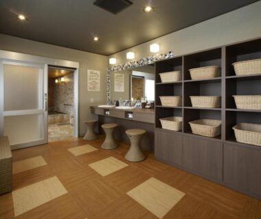 Changing room with wooden shelving and woven baskets, vanity sinks and stools at Wakamatsu Honten in Chiba, Kantō