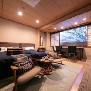 Tatami seating area with low table and twin beds at Wakamatsuya in Yamagata, Tōhoku, Japan
