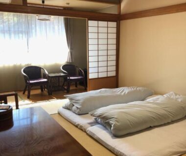 Tatami room with futons and shoji screens at Wakamizusou in Yamanashi