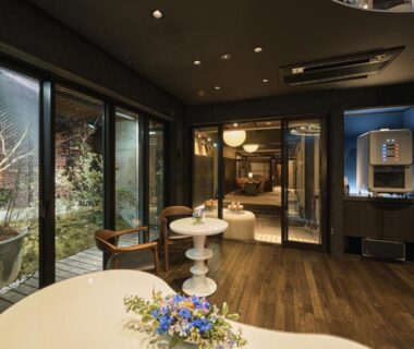 Interior lounge with round tables, wooden floor and garden view at Wakasa Annex in Nara