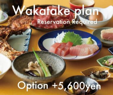 Assorted traditional Japanese dishes including sashimi and grilled fish served on a low table at Wakatake in Wakayama