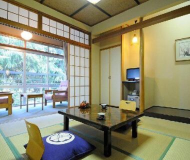 Traditional tatami room with low table, zabuton cushions and sliding shoji doors opening to garden