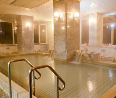 Tiled indoor communal onsen with handrail and shower stations at Wakayama Kada Kaigetsu, Kansai Japan