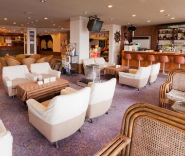 Upholstered lounge chairs, low wooden tables and bar counter at Kada Kaigetsu, Wakayama