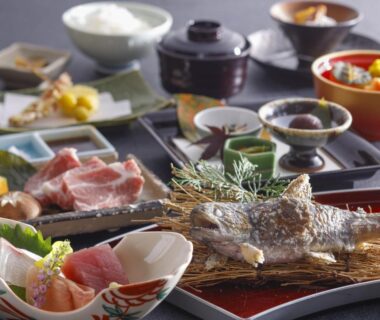 Multi-course meal with grilled fish, sashimi, sliced beef and side dishes at a ryokan in Mie prefecture