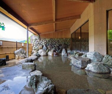 Sheltered rock-lined onsen bath at Wan Wan Paradise Matsusaka in Mie, Kansai