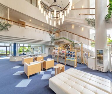 Airy lobby seating area with staircase and retail display at Wan Wan Paradise Premier Izukogen, Shizuoka