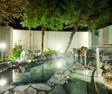 Stone open-air onsen lit at night at Wan Wan Paradise Premier Shiobara Tochigi