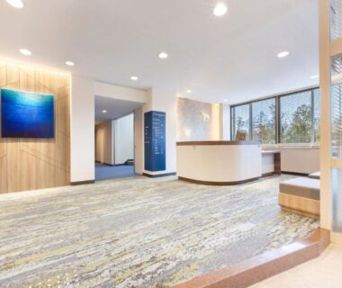 Bright lobby with reception desk, bench seating, artwork and windows overlooking trees at Wan Wan Paradise Premier Yamanakako Yamanashi