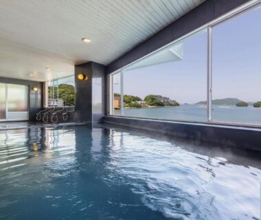 Indoor onsen bath with large windows overlooking coastal islands near Toba Mie prefecture