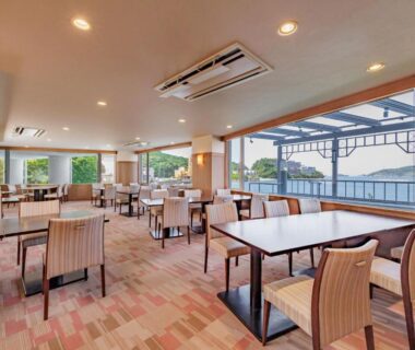 Dining area with tables and large windows at Wan Wan Paradise Toba, Mie