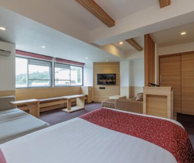 Bright modern twin room with bench seating and large window at Wan Wan Paradise Toba in Mie