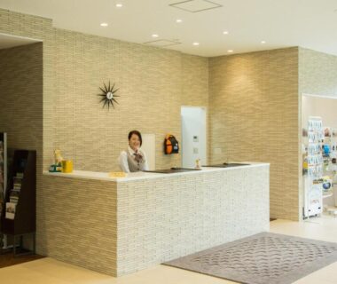 Reception desk with staff, brochure rack and vending area at Wan Wan Paradise Yatsugatake, Yamanashi