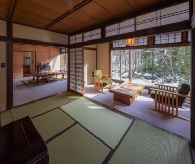 Traditional tatami room with low table, shoji screens and seating overlooking a garden at Wanosato, Gifu