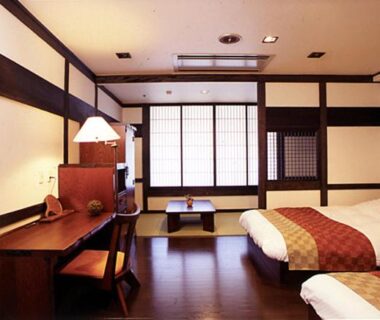 Interior with shoji screens, low table, desk and twin beds at Wasuki Tsukasakan, Kumamoto, Kyushu, Japan