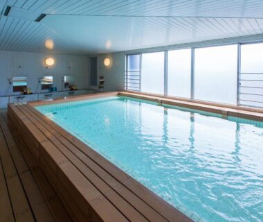 Bright indoor bathing pool with wooden deck at Wasuki Tsukasakan in Kumamoto, Kyūshū, Japan