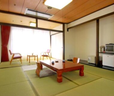 Traditional tatami room with low wooden table, floor cushions, shoji screens and window seating at Wasuki Tsukasakan, Kumamoto