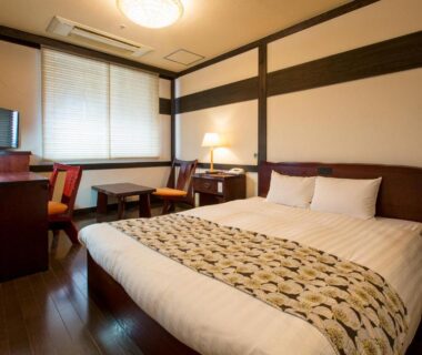 Western-style room with double bed, desk, chairs, shoji window and wooden floor at Wasuki Tsukasakan, Kumamoto