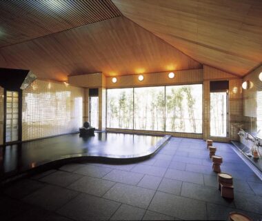 Spacious indoor onsen bath with wooden ceiling and stools at Watarase Onsen Hotel Sasayuri, Wakayama, Kansai