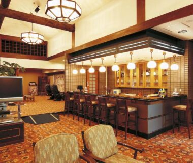 Warm wooden lobby bar with counter seating and hanging lanterns at Watarase Onsen Hotel Sasayuri Wakayama