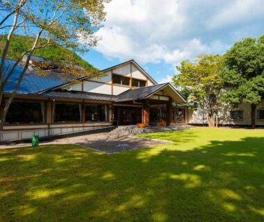 Green lawn and traditional wooden ryokan exterior at Watarase Onsen Hotel Sasayuri in Wakayama, Kansai, Japan