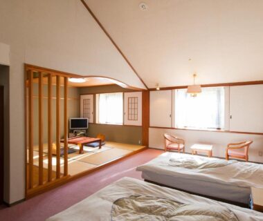 Japanese room with tatami seating, twin beds and low table at Watarase Onsen Hotel Sasayuri, Wakayama