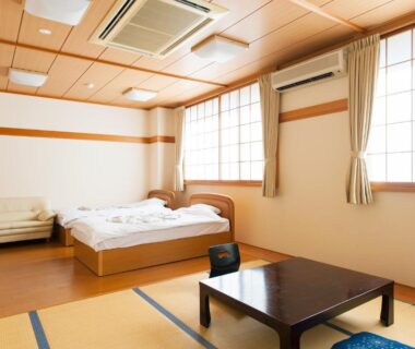 Interior tatami room with low table and Western bed at Watarase Onsen Hotel Yamayuri, Wakayama, Kansai Japan