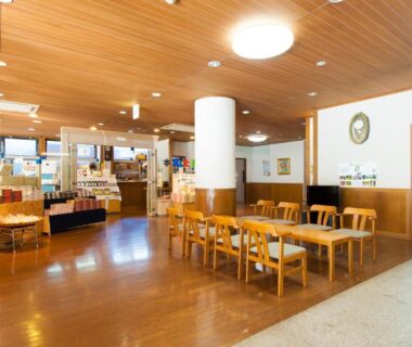 Wood-paneled lobby with tables and souvenir displays at Watarase Onsen Hotel Yamayuri, Wakayama