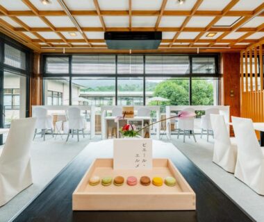 Dining area with white covered chairs and colorful confections at Wataya Besso, Saga, Kyūshū, Japan