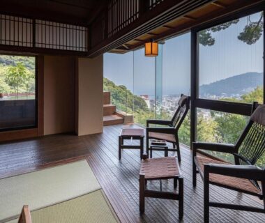 Tatami seating with wooden chairs and large windows at Watei Kazekomichi, Shizuoka