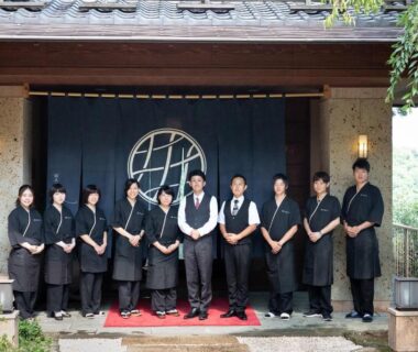 Ryokan entrance with lined staff and traditional noren at Watei Kazekomichi in Shizuoka, Japan