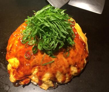 Okonomiyaki topped with shredded shiso and savory sauce at Wholeearth Ryokan Hiroshima, Chūgoku, Japan